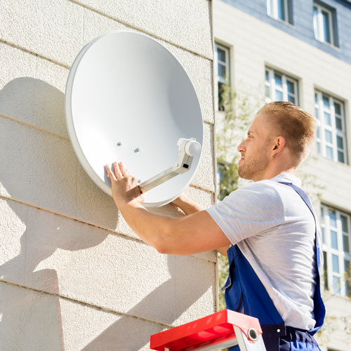 Satellite Engineer Fitting TV Satellite Dish To Wall